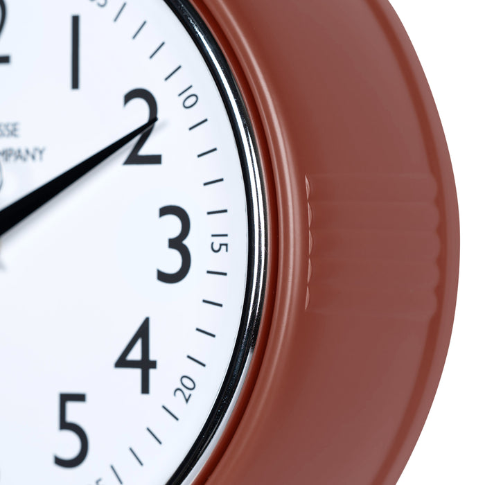 Close-up frame image of the 404-3024TC 9.5-inch Diner Clock – Terracotta features a retro-style terracotta frame with a white dial, chrome bezel, black numbers and minute markings, black metal hands, and a silver second hand.