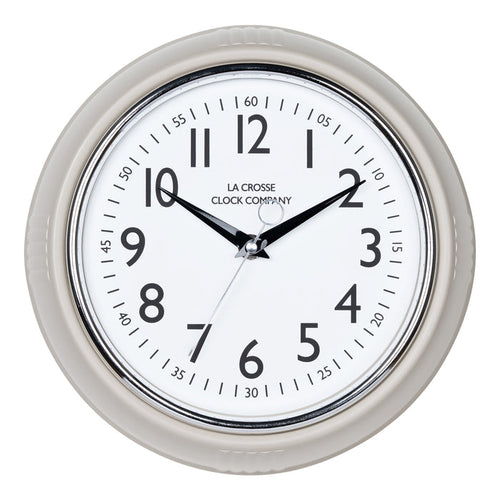 Head-on image of the 404-3024TP 9.5-inch Diner Clock – Taupe. The clock features a retro-style taupe frame with a white dial, chrome bezel, black numbers and minute markings, black metal hands, and a silver second hand.
