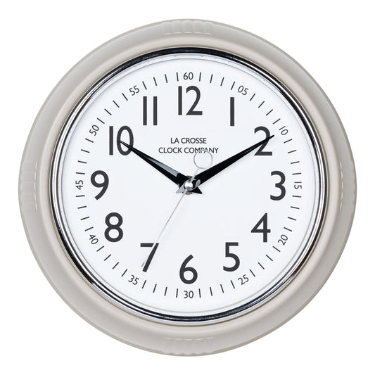 Head-on image of the 404-3024TP 9.5-inch Diner Clock – Taupe. The clock features a retro-style taupe frame with a white dial, chrome bezel, black numbers and minute markings, black metal hands, and a silver second hand.