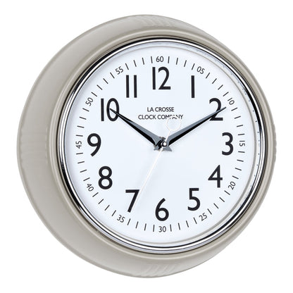 Right-facing image of the 404-3024TP 9.5-inch Diner Clock – Taupe. The clock features a retro-style taupe frame with a white dial, chrome bezel, black numbers and minute markings, black metal hands, and a silver second hand.