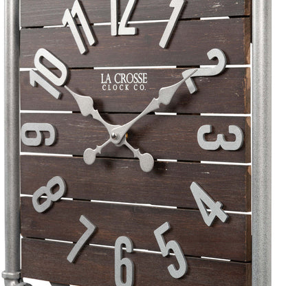 Close-up frame image of the 404-3412L 16-inch Foundry Metal & Wood Wall Clock - Light. The clock features a square metal pipe frame, stained wood slats, and metal pewter finish accents.