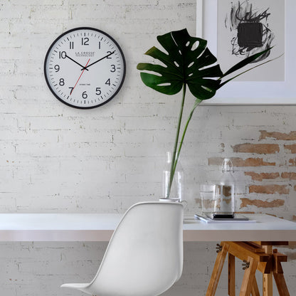 404-3730 Modern interior with a clock on the wall, white chair, and plant.