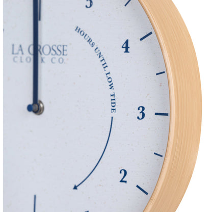 Close-up image of the natural wood frame detail of the 425-3831 11.8-inch Tide Wall Clock. The clock features a light wood frame, a white and tan speckled dial, blue numbers, markings, and a blue metal hand.