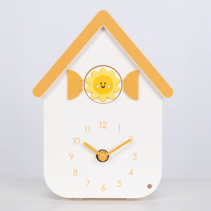 Head on image of W70063, a white house shaped clock with a smiley sun cuckoo with yellow numbers, shutters, roof, and hands