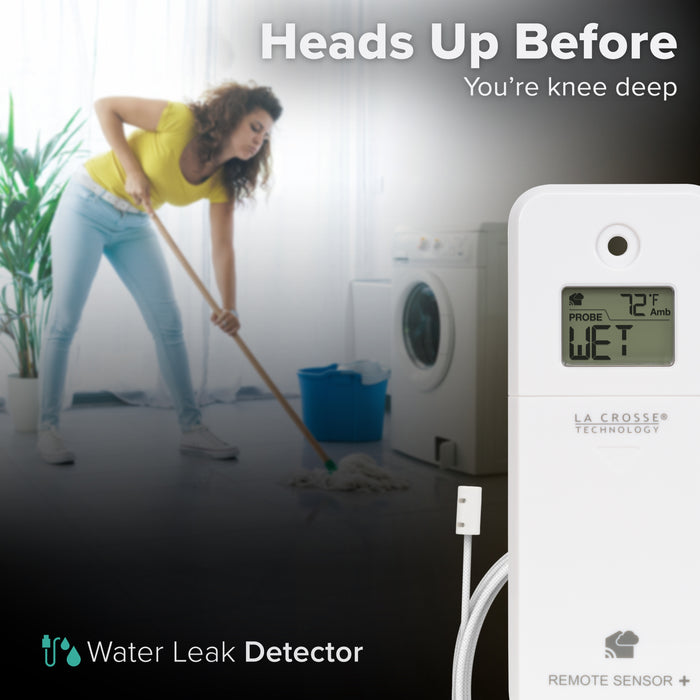White alert and monitoring water leak area detection sensor with a braided cable in the foreground displaying an LCD screen reading wet and ambient temperature reading of 72 degrees Fahrenheit with a woman in a yellow t-shirt and jeans mopping up a floor in front of a front-load washing machine in the background